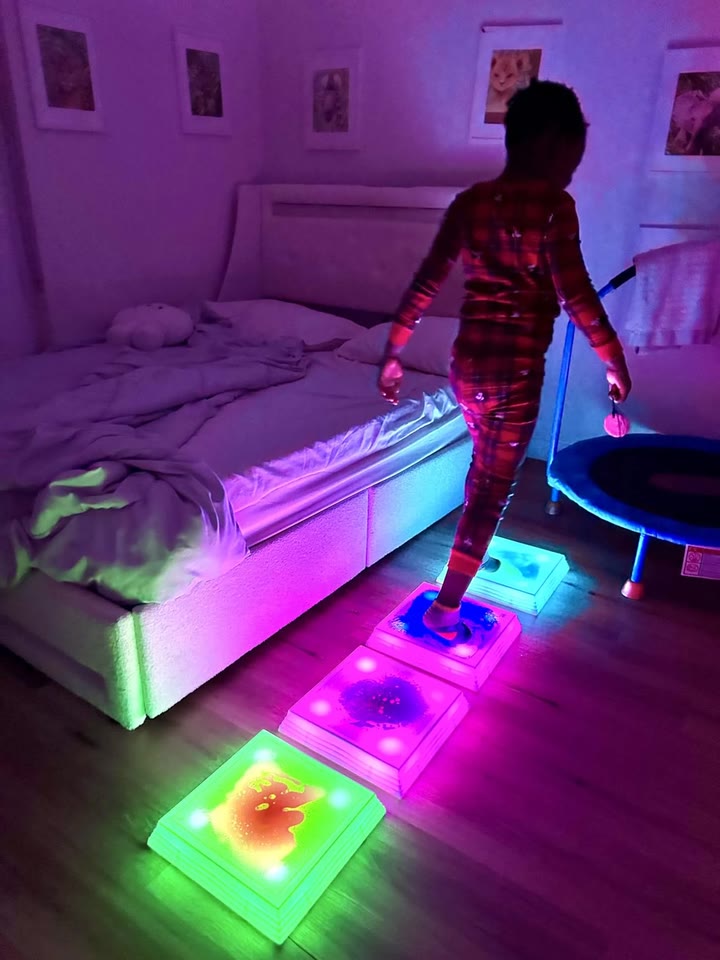 A child in pyjamas stepping across glowing liquid squares in a bedroom