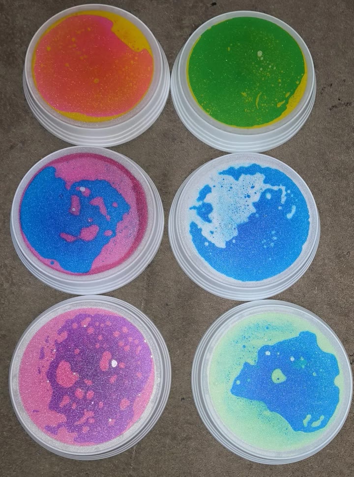 Six liquid gel stones seen from above on a carpet