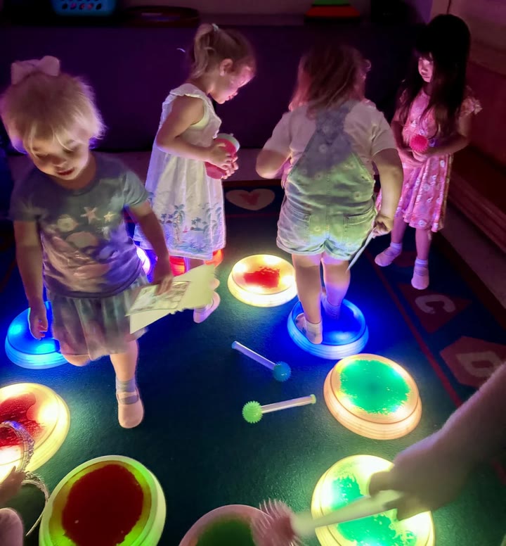 Children stepping on glowing stones in a playroom