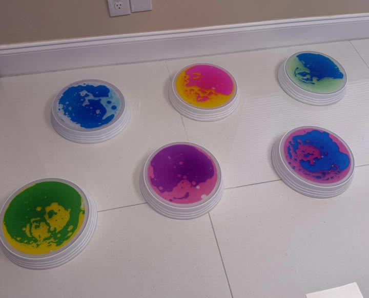 Six liquid gel stones laid out on a tiled floor