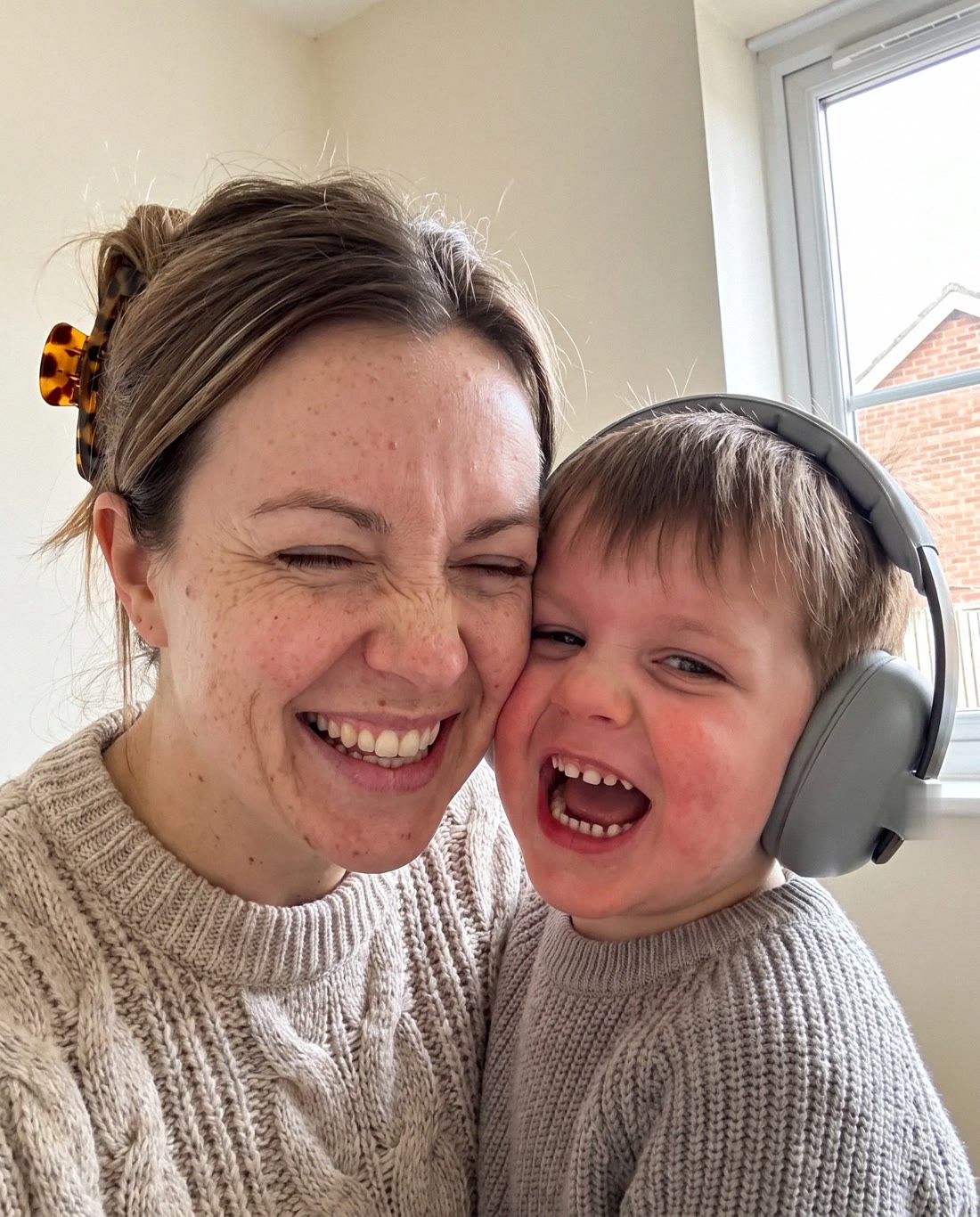 Tracy and her son Joshua laughing cheek to cheek at home